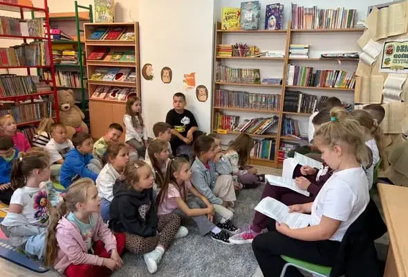 Dzień Głośnego Czytania w bibliotece szkolnej – starsi uczniowie czytali młodszym